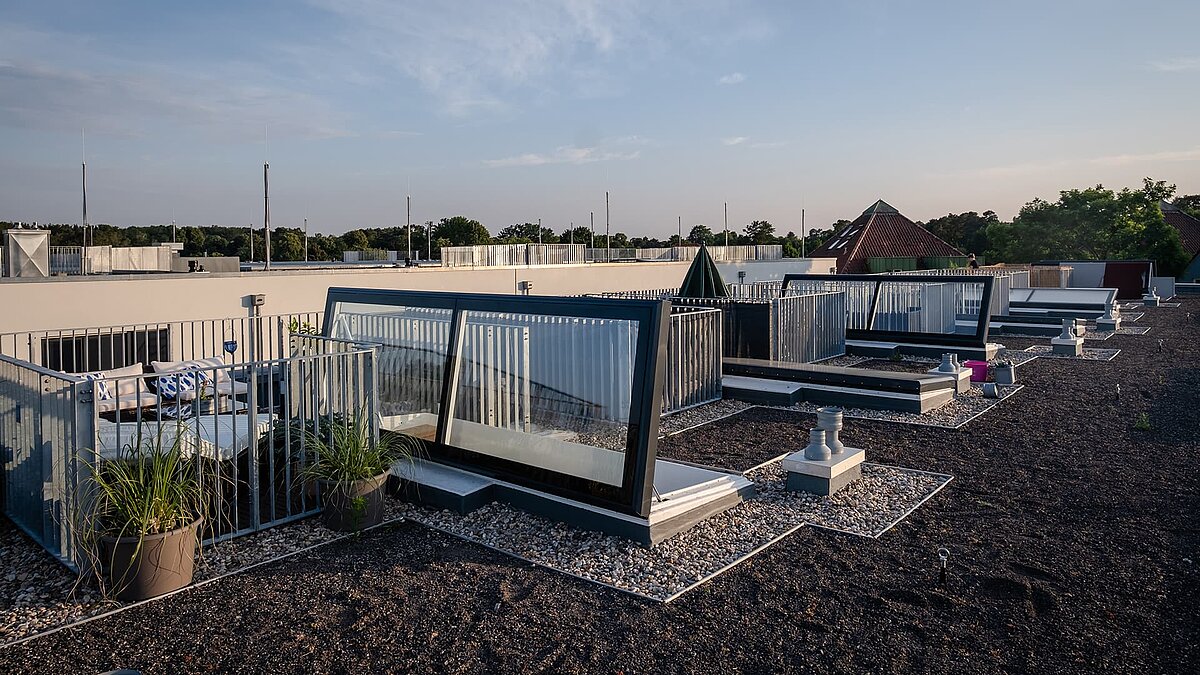 Flat roof with exits and private terraces at Townhouse Berlin during sunset.