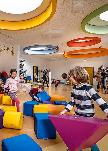 Children playing in a colorfully decorated room.