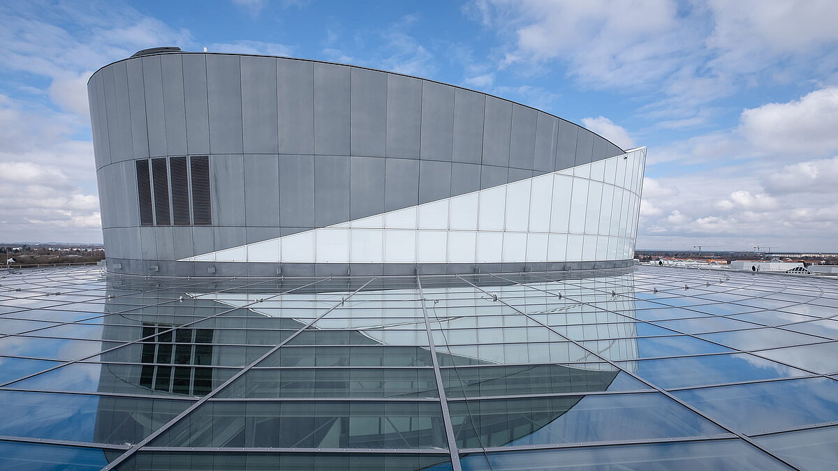 Exterior view of the BMW Group Research and Innovation Centre (FIZ) showcasing its distinctive architecture with a curved facade.
