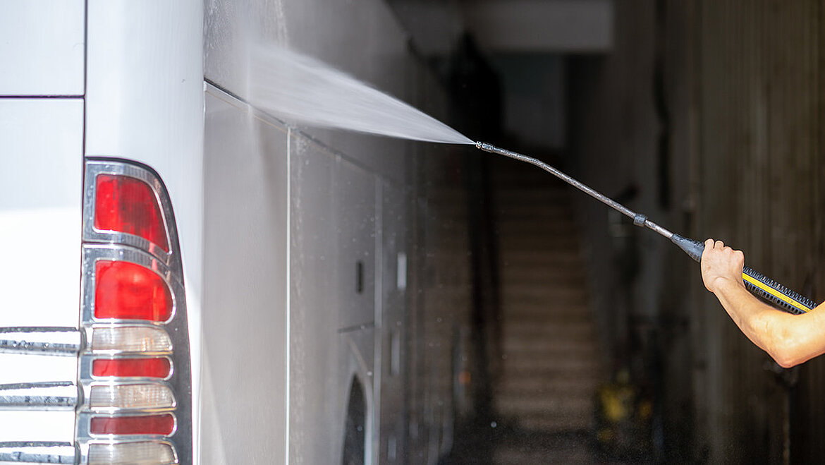 Cleaning of a bus side wall with steam jet Man with steam jet washes bus side wall | insights by LAMILUX