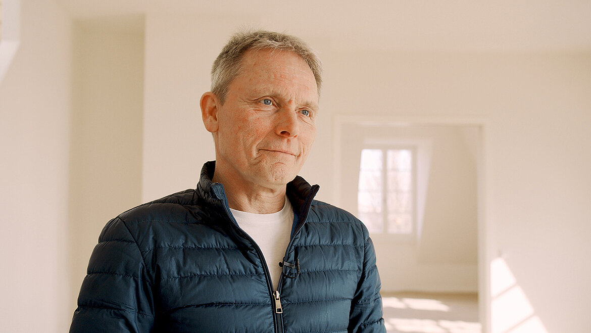 Man standing in a bright interior speaking
