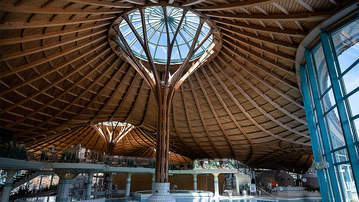 Interior with distinctive wooden structure and circular skylight at the center of the roof