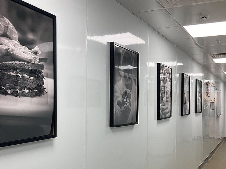 Black and white photos hanging in a lit corridor