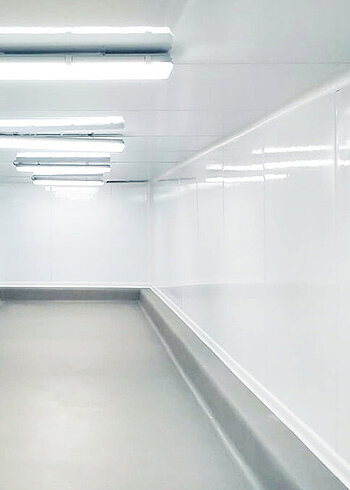 Empty, white corridor with bright lighting.