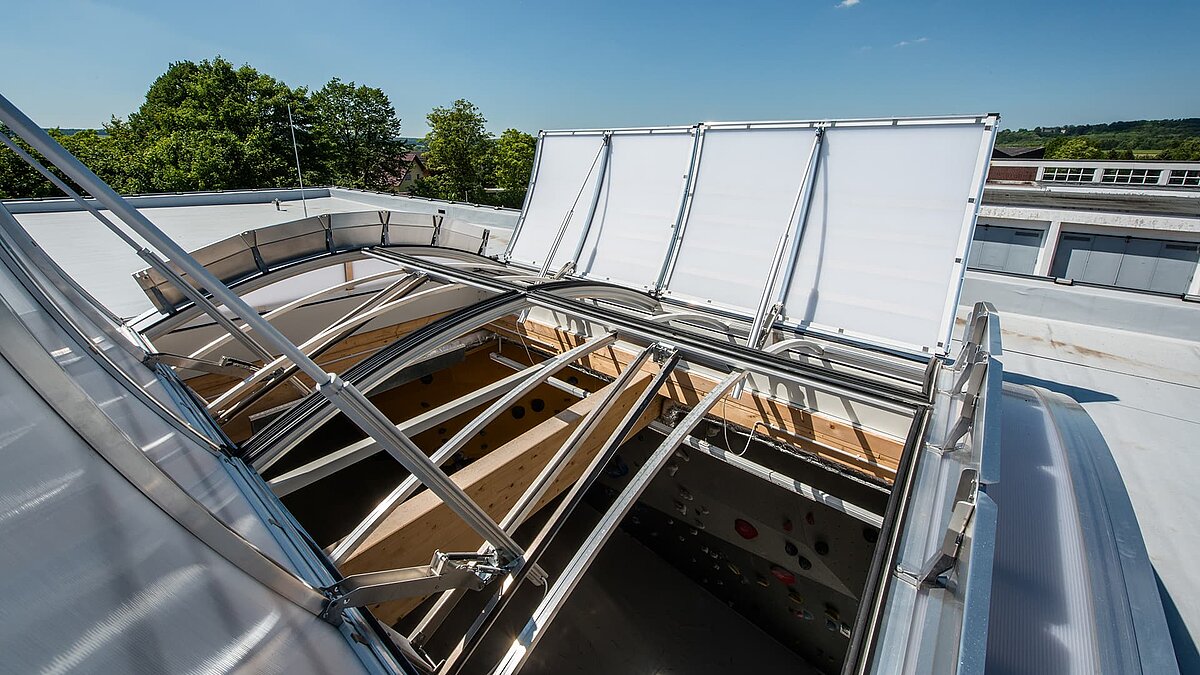 Open skylight on the roof of the OWL climbing center, allowing daylight into the climbing hall with a climbing wall.
