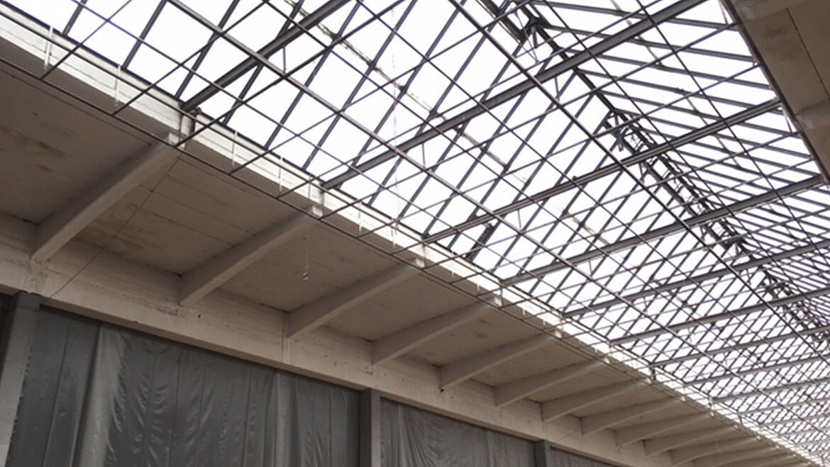 Large glass roof with delicate steel structure above a modern interior area