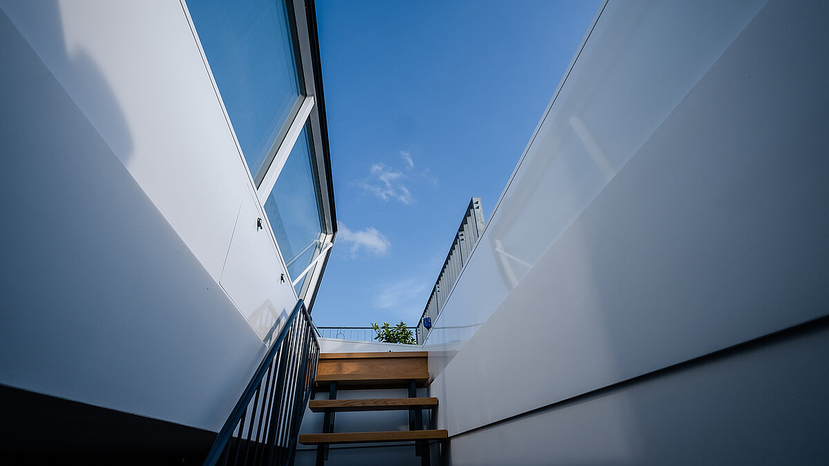 View from inside the flat roof exit of a townhouse in Berlin with blue sky in the background.