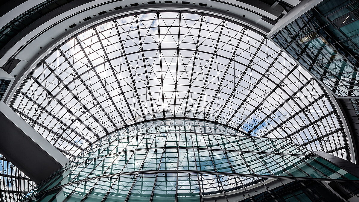 Large, curved glass roof structure in the BMW Group Research and Innovation Centre (FIZ) with impressive natural light and modern architecture.