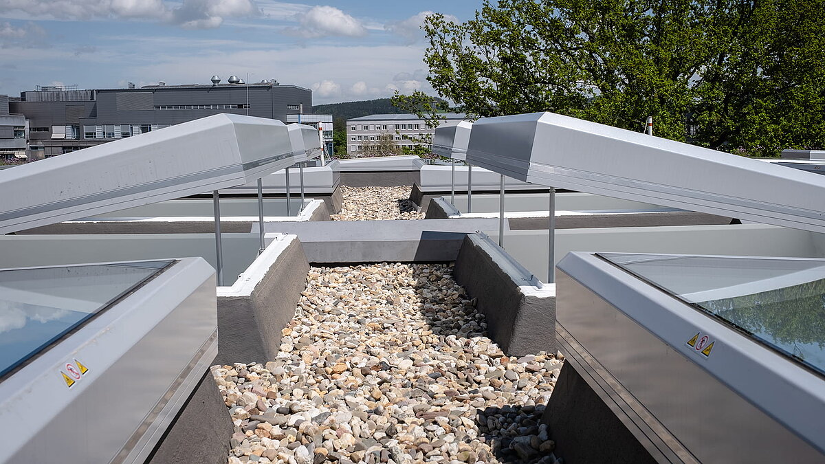 Rooftop view of the Weiden district court with open, modern skylights and gravel covering.