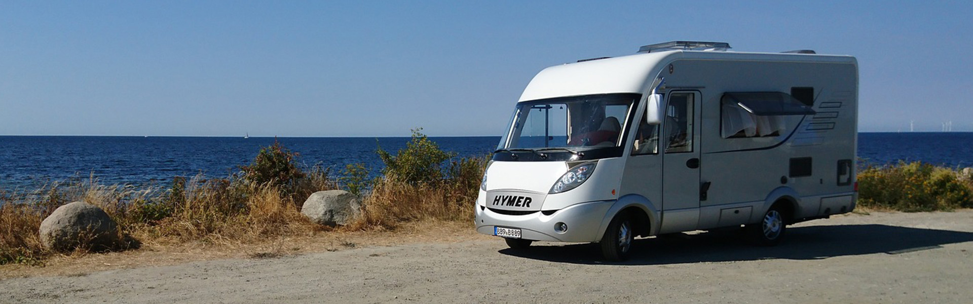 Caravan am Meer vor blauen Himmel | insights by LAMILUX