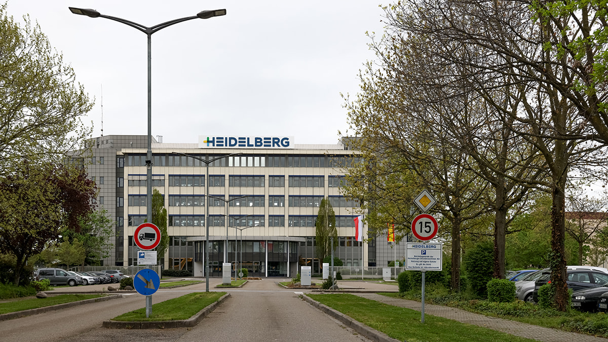 Exterior view of the Heidelberger Druckmaschinen building with trees and parking lots.