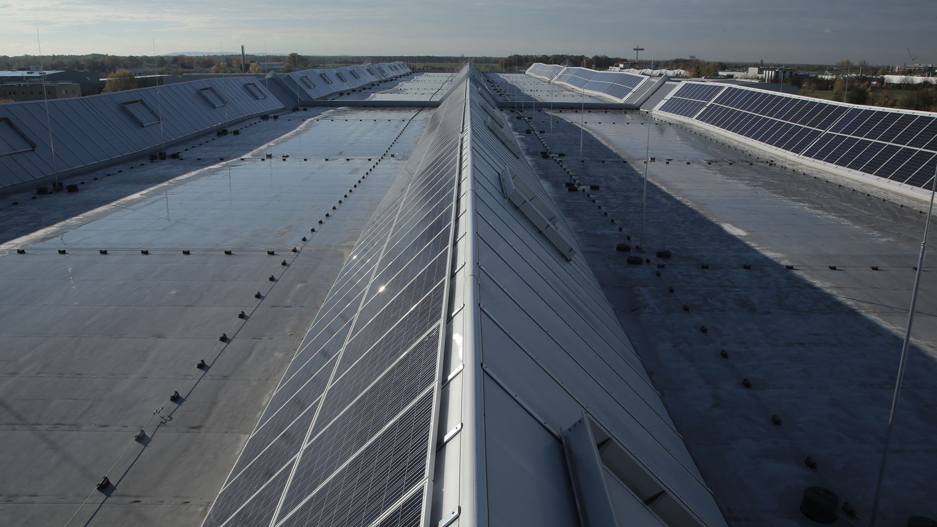 Roof of the Rhenus Logistics logistics center in Hoppegarten featuring LAMILUX Lichtband S and solar panels.