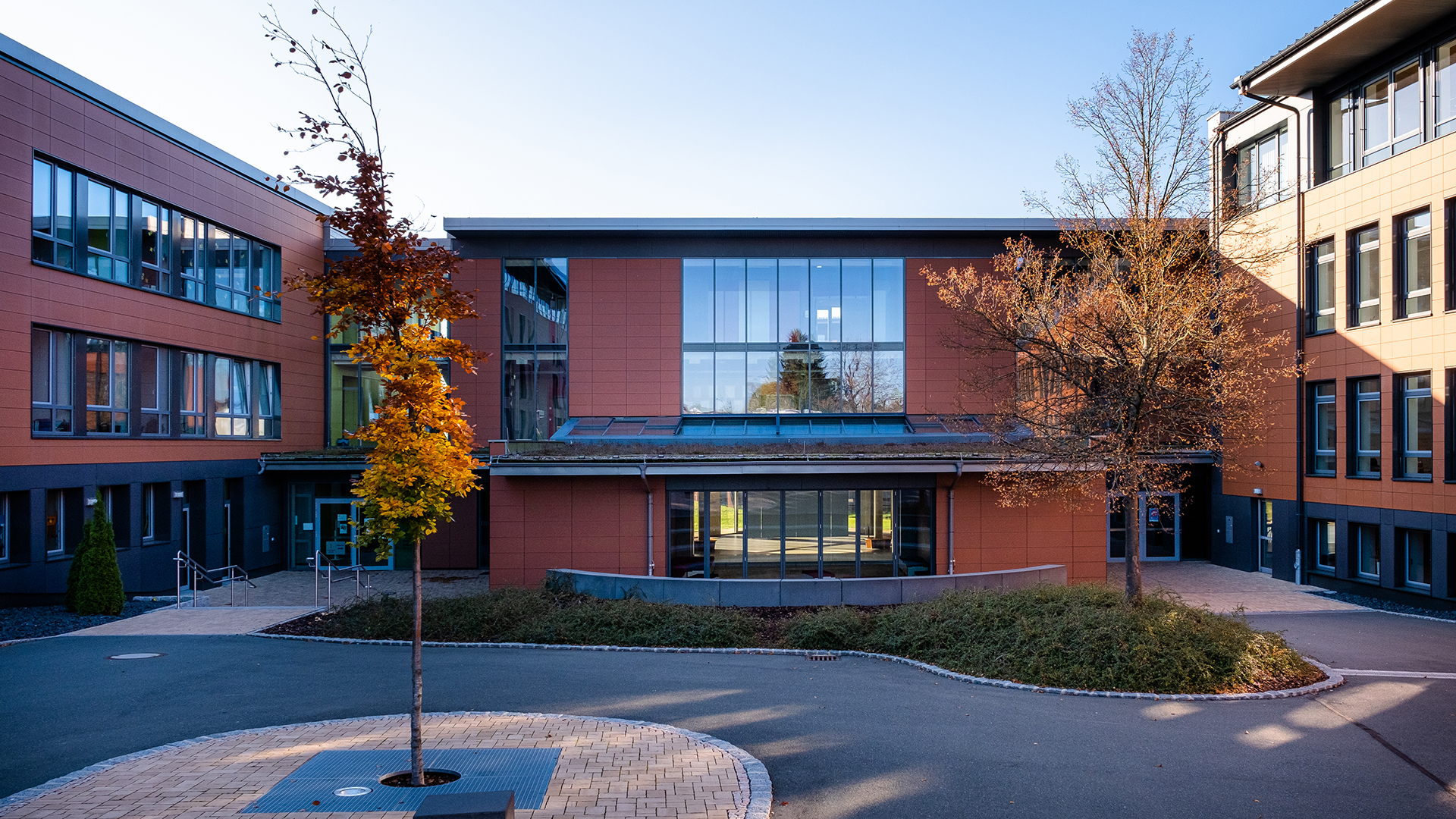 Rehau school center featuring modern architecture, large glass facades, and a green roof.