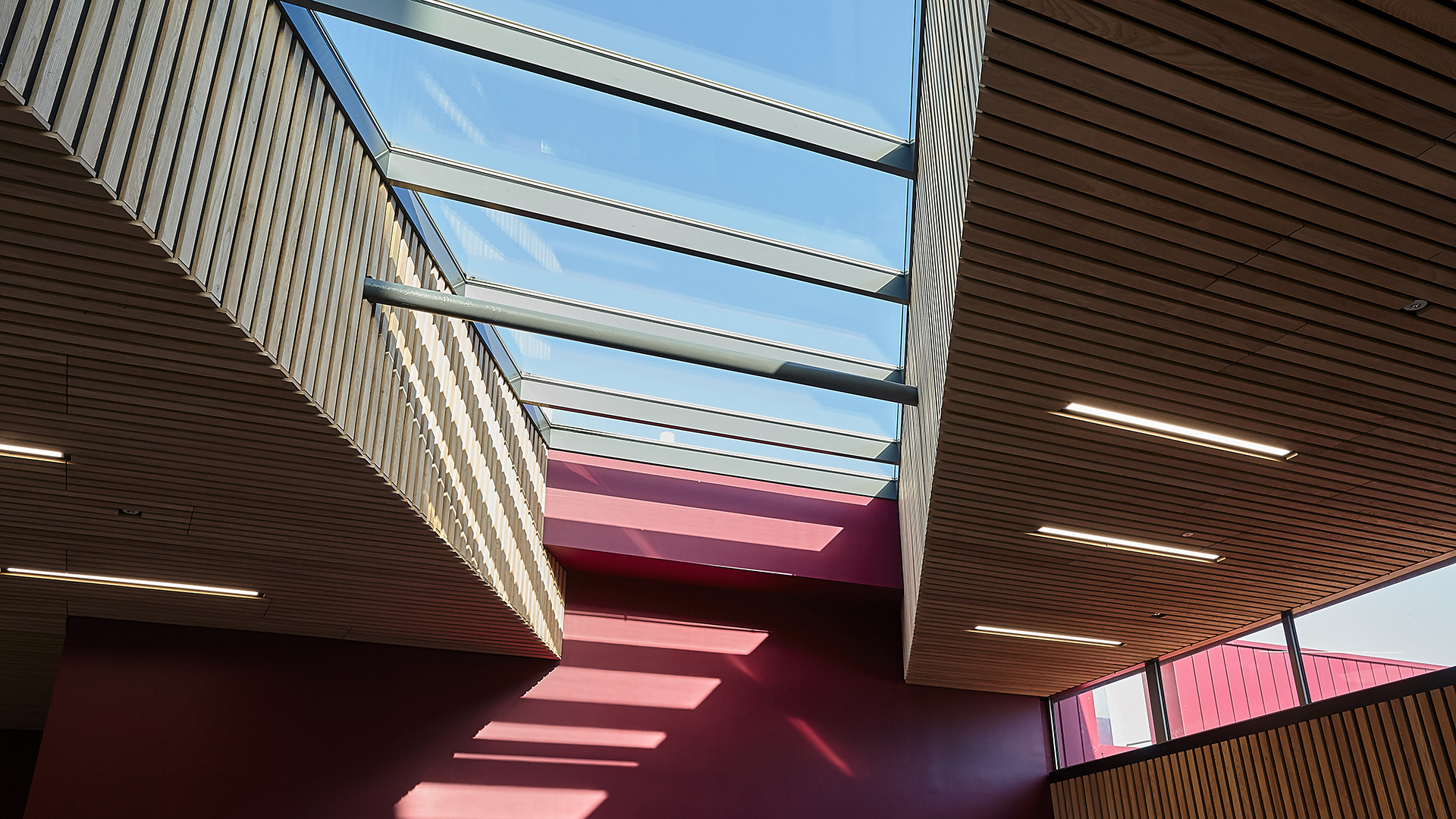 Interior view of Sheffield Hallam University featuring LAMILUX PR60 glass roof and modern wooden ceilings.