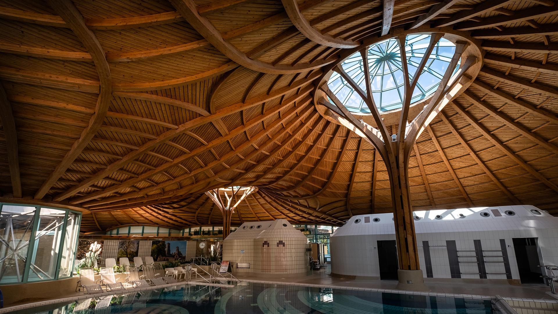 Interior view of the Solemar thermal spa in Bad Dürrheim featuring a wooden ceiling structure and a large glass dome.